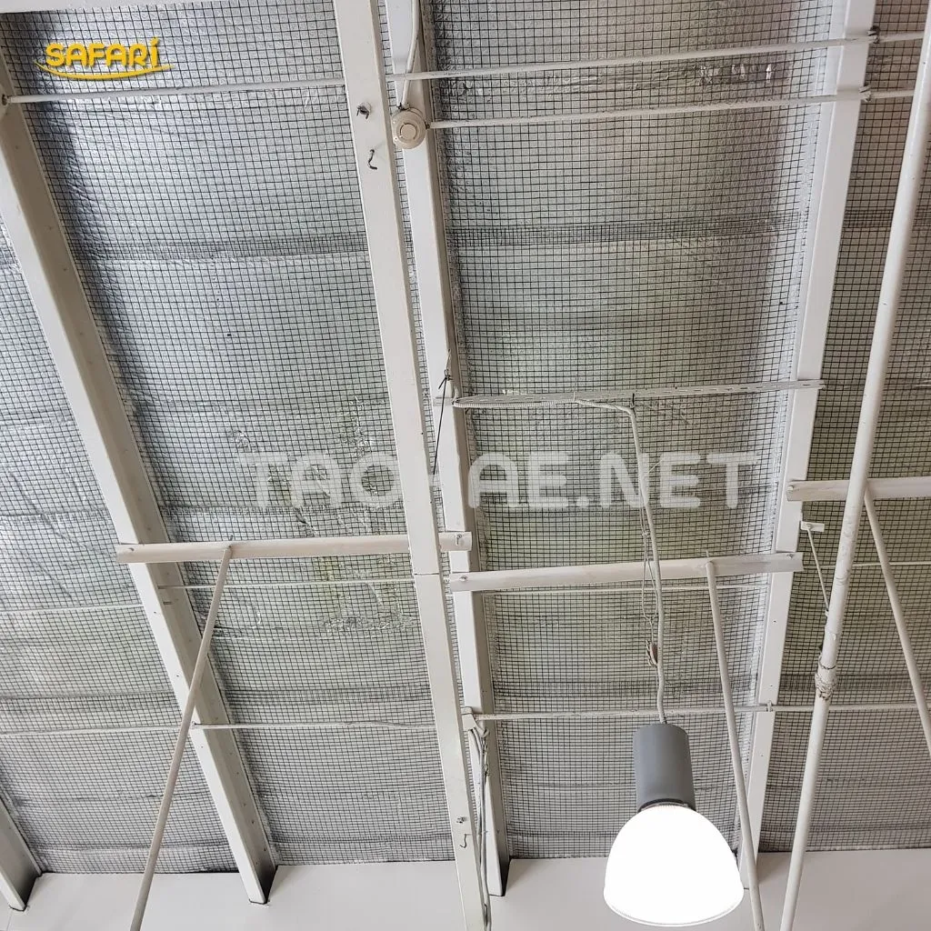 ตาข่ายลวดเหล็กถักละเอียดขึงตึงติดกับโครงหลังคาเหล็กสีขาว เพื่อปิดช่องว่างใต้หลังคาโรงเรือนอย่างมิดชิด